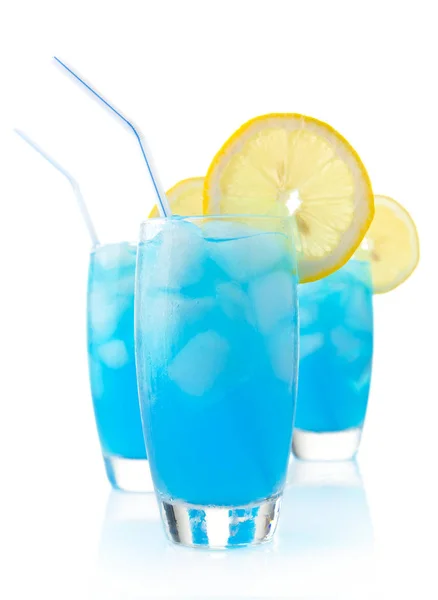 Cocktail blu laguna con cubetti di ghiaccio, limone e paglia su bianco Immagine Stock