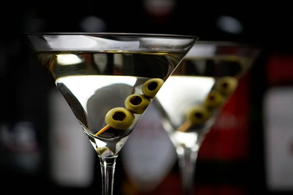 Primo piano dei cocktail Martini con olive al bar sul nero Immagini Stock Royalty Free