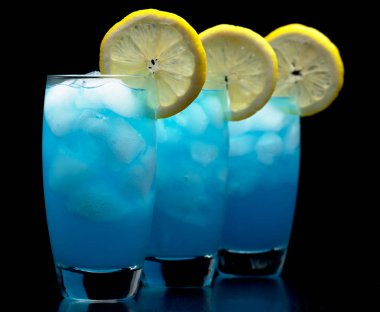 Siyah üzerinde izole limon dilim ile mavi lagün içecekler