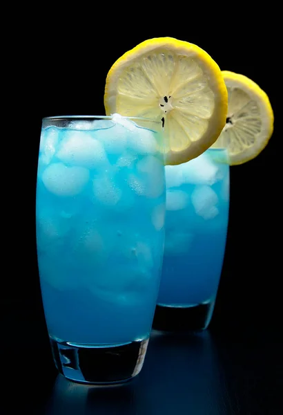 Blue lagoon cocktails with slice of lemon isolated on black — Stock Photo, Image