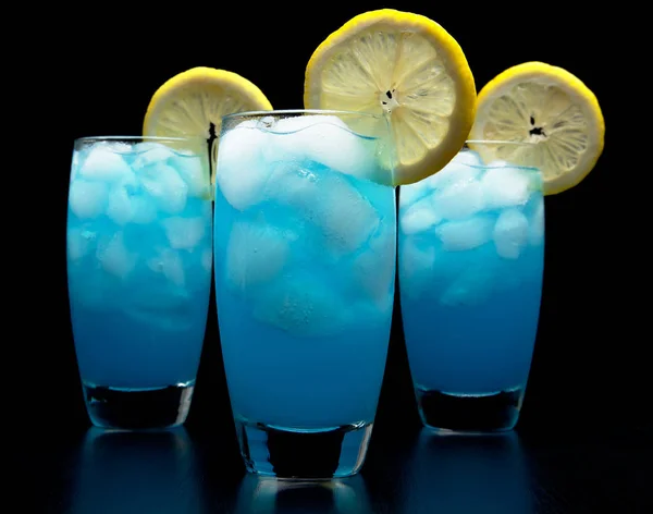 蓝色泻湖饮料与柑橘片隔离在黑色 — 图库照片