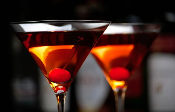Манхэттенские напитки с вишней и баром на заднем плане — стоковое фото