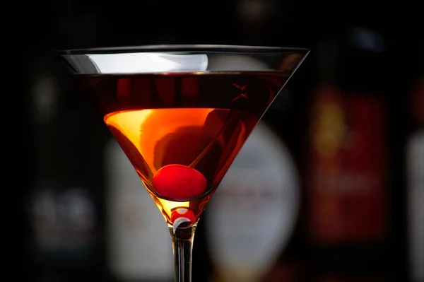 Manhattan bebida com cereja com bar no fundo — Fotografia de Stock