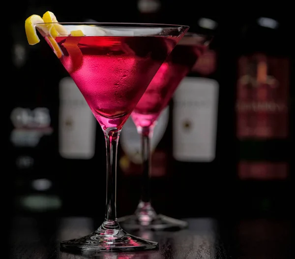Zwei kosmopolitische Cocktails in Bar auf schwarz — Stockfoto