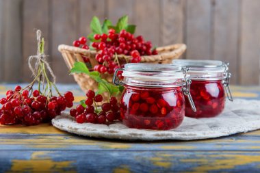 Olgun kırmızı kartopu meyveler ve küçük bir bardak ile ışık ahşap bir masa üzerinde taze hazırlanmış reçel kavanoz. Sonbaharda hasat. Doğal vitamin kaynağı. Halk tıbbında kullanılan.