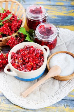 Olgun kırmızı kartopu meyveler ve küçük bir bardak ile ışık ahşap bir masa üzerinde taze hazırlanmış reçel kavanoz. Sonbaharda hasat. Doğal vitamin kaynağı. Halk tıbbında kullanılan.