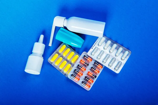 Nasal spray, nasal drops, pills in the blister, throat spray, Modern medicines for colds, flu.
