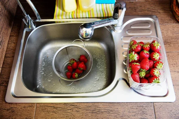 在厨房的水槽里洗水果和草莓 — 图库照片