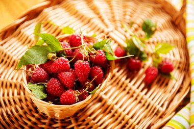 Ahşap bir masada sepetteki ahududu, yeni bir mahsul.