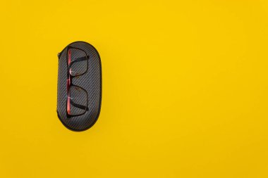 Sarı arka planda gözlük ve koruyucu kılıf