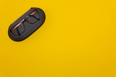 Sarı arka planda gözlük ve koruyucu kılıf