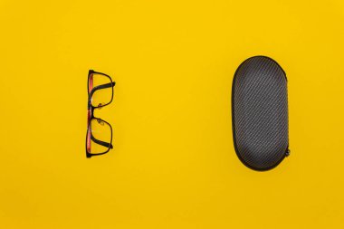 Sarı arka planda gözlük ve koruyucu kılıf