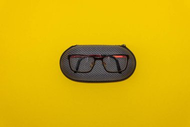 Sarı arka planda gözlük ve koruyucu kılıf