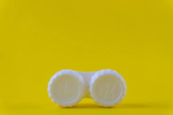 Caja de almacenamiento de lentes de contacto borrosas sobre fondo amarillo — Foto de Stock
