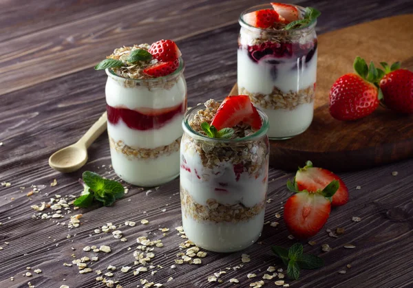 Reçelli yoğurt, müsli ve taze çilek, nane yaprağı. Sağlıklı kahvaltı kavramı.