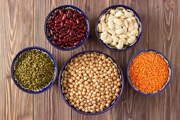 Ahşap arka planda nohut, mercimek, fasulye ve fasulye. Üst görünüm.