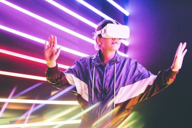 Renkli neon ışıklar stüdyosunda VR gözlük kullanan bir kız.