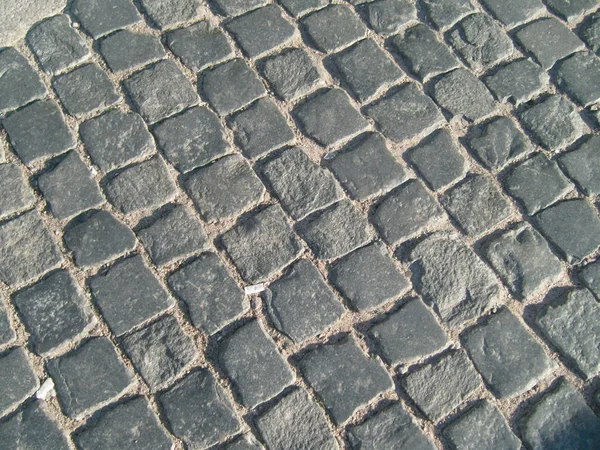 Pavimento de paralelepípedos na cidade velha. Pedra cinzenta artesanal — Fotografia de Stock