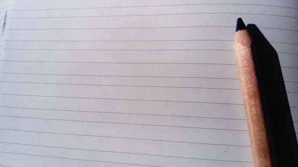 Çizgili bir sayfada bir kalem yer alır. Birinci sınıfta ilk kez. Öğrenci defteri — Stok fotoğraf
