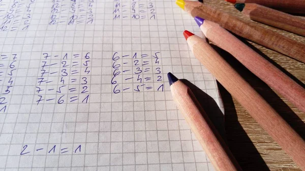 Exemplos de problemas aritméticos são escritos em colunas em uma folha em uma célula — Fotografia de Stock