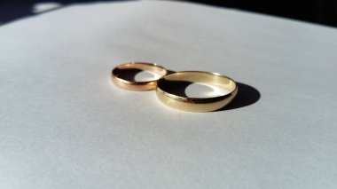 Altın alyanslar, büyük ve küçük, erkek ve kadın. Beyaz arka plan.