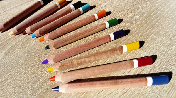 Su un tavolo ci sono diverse matite di legno di spessore colorato — Foto Stock