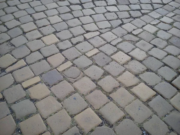 Geplaveide plein van de oude stad van vierkante stenen. Bestrating van grijze en bruine stenen. De herfst — Stockfoto