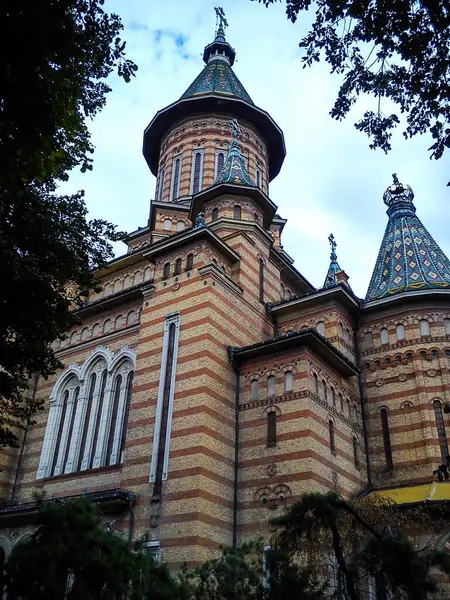 Temisoara, Rumunsko - 6. října 2019 Hlavní kostel města. Cihlové stěny, tradičně zdobené střechy, půlkruhová vysoká okna — Stock fotografie