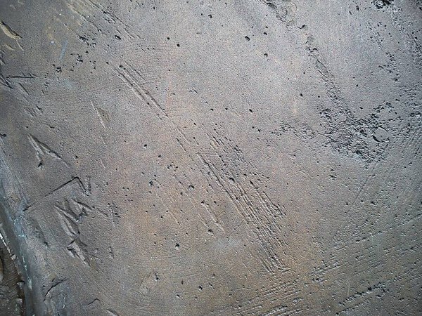 Slice on metal. Fragment of a metal sculpture with an uneven surface. Noticeable roughness and small flaws formed during lithium alloy