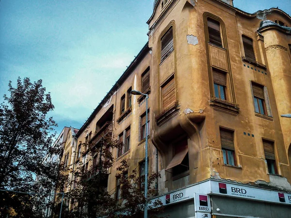 Timisoara, Rumania - 21 de octubre de 2019, fachada de un antiguo edificio con pelado de estuco en lugares, en la planta baja de la cual hay una sucursal de un banco comercial — Foto de Stock