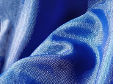 Mavi ipek astar. Yakın plan. Perdelerde kumaş parçası ya da yağmurluk..