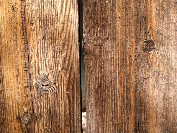 Close-up teak wood textured background. Vertical boards with places where there were knots. Mahogany or ginger color. Natural texture. Rough wood surface.