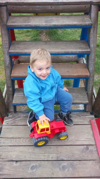 Pojke Leker Med Traktor Bakgården Barnet Klädd Blå Jacka — Stockfoto