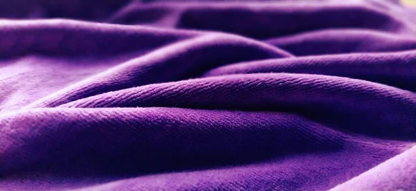 Purple velvet. Soft fabric. Blurred edges of the photo