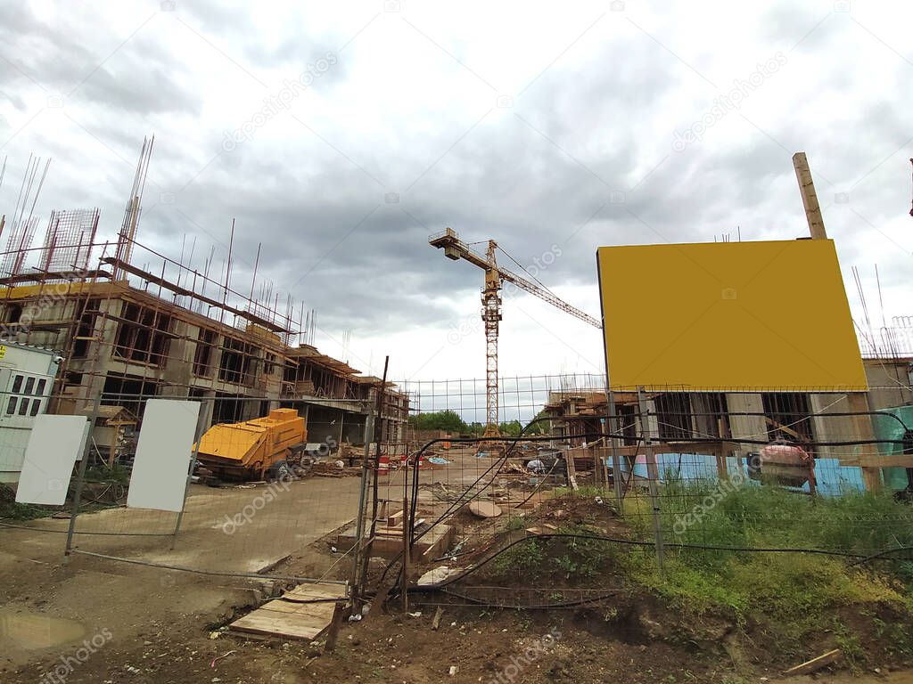 Sremska Mitrovica, Serbia. June 10, 2020. Construction of an apartment building under the state program for refugees, police and military personnel. Billboards, building materials and crane.
