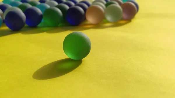 Boules Dépoli Verre Bleu Vert Sur Une Surface Jaune Partiellement — Photo