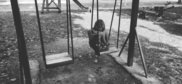 Uma Menina Baloiço Rapariga Está Triste Sozinha Recreio Imagem Monocromática — Fotografia de Stock