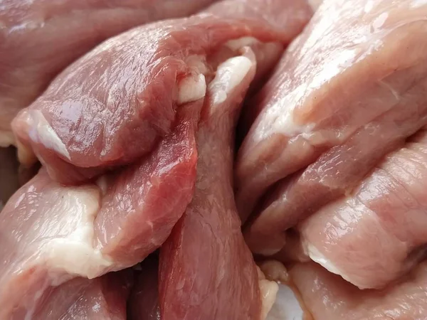 Bir parça et. Çiğ domuz eti. İnce damarlar ve etin dokusu. Koyu kırmızı bölgeleri olan pembe et. Satılık taze et ürünleri. Marketin et bölümünün çeşitli ürünleri..