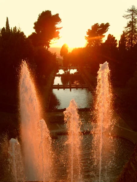 ヴィラ エステの創設者 丘の上にラツィオ地域のティヴォリ郊外のヴィラ エステ 夕方の夕日のウォータージェット 光線は水で遊ぶ — ストック写真