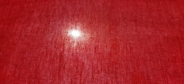 Sun or lamp through red blackout curtains. Bright red background with a glowing circle. Counter light