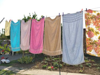 Sremska Mitrovica, Sırbistan 10 Temmuz 2020, havlular ve giysiler iple kurudu. Ev hanımı endişeleniyor. Islak bez daha fazla kuruması için mandallara asılır. büyük çamaşır.