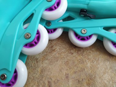 Beyaz, pembe, turkuaz ve yeşil renkli bigudiler. Poliüretan ya da silikon castor. Spor malzemeleri yerde yatıyor.