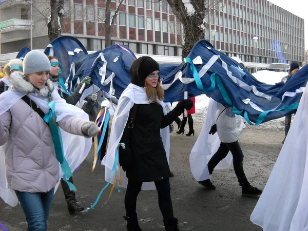 Petrozavodsk, Rusia - 19 de noviembre de 2019 - demostración festiva de invierno. Los jóvenes llevan paisajes a lo largo de la calle, que representan una ola de mar y agua. Las niñas se adornaron con cintas de tela ancha — Foto de Stock