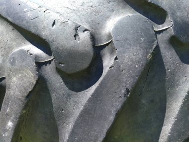 Traktör ya da kamyon tekerleği lastiği. Siyah kauçuk yakın plan. Hasar ve çatlaklar. Doğal ve sentetik prezervatiflerden ve kablodan yapılmış kauçuk dokusu. Kordon kumaşı.