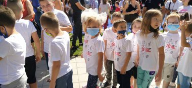 Sremska Mitrovica, Sırbistan, 01 Eylül 2020. Çocuklar okula gider. Covid-19 salgını sırasındaki Bilgi Günü. Birinci sınıflar çifttir. Beyaz kurdeleli kız maske takıyor..