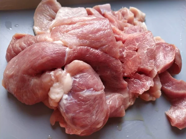 灰色の表面に豚肉の肉のジューシーな大片 肉は解凍または蒸し そこから血ジュースが流れます 切って調理するためのおいしい新鮮な肉 — ストック写真