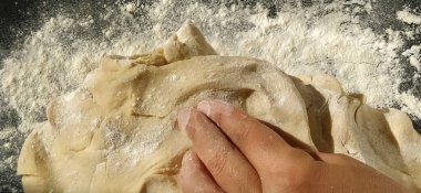 Eller hamuru yoğurur. Kadın hamur yoğurma ya da hamur işi için yoğurdu. Un, su ve yumurta kütlesinin termal işleme için hazırlanması. Şefin elleri.