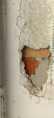 Betondaki boşluk, kavramsal arka plan. Tuğlalar, çimento, beton, yamalar duvardaki delikten görülebilir.