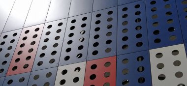 Modern bir binanın cephesi. Kırmızı, mavi ve beyaz levhalar ya da dekoratif delikli metal profiller. Dış yüzeyde teknolojik çözümler. Dekoratif elementler altında destekleyici yapılar inşa ediliyor.