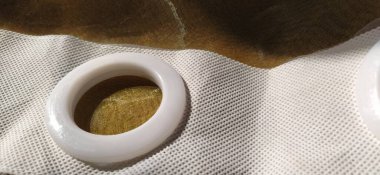 Kumaşı perde kordonuna bağlamak için plastik halkalar. Beyaz plastik tül göz bebekleri. Açık renkli perdeler, bej, kahverengi ya da turuncu renkler. Beyaz, dokumasız kumaş. Tekstil kenarı bitmiş. İç öge